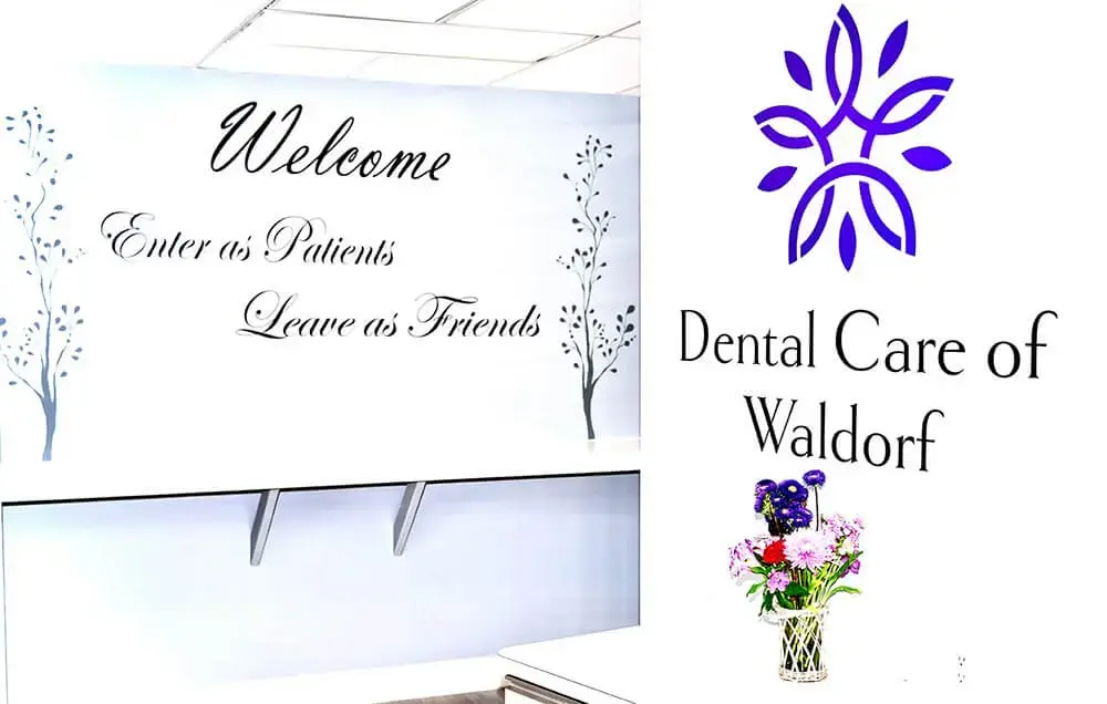 Reception area wall featuring a "Welcome, Enter as Patients, Leave as Friends" sign beside the Dental Care of Waldorf logo and a vase of colorful flowers