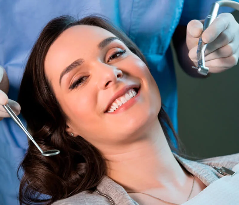 Smiling patient relaxing in a dental chair during a dental exam