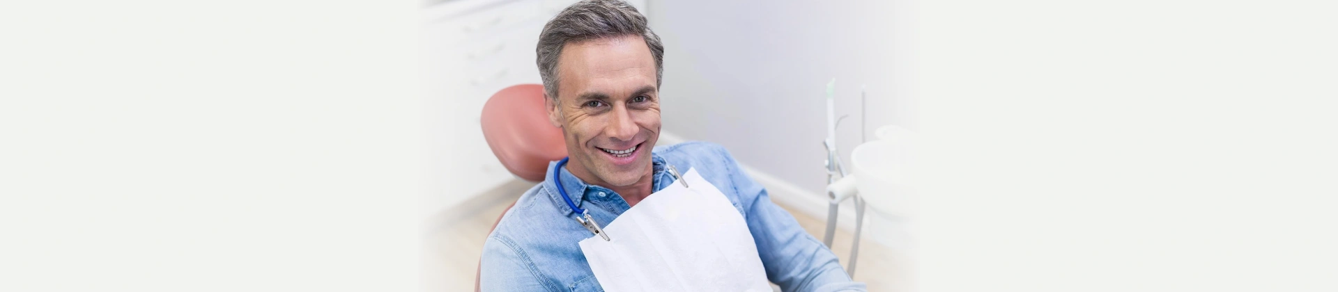 Smiling patient seated in a dental chair before treatment