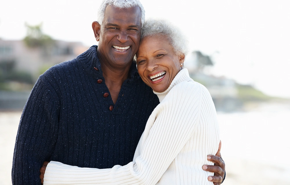 Couple embracing on a beach and smiling together